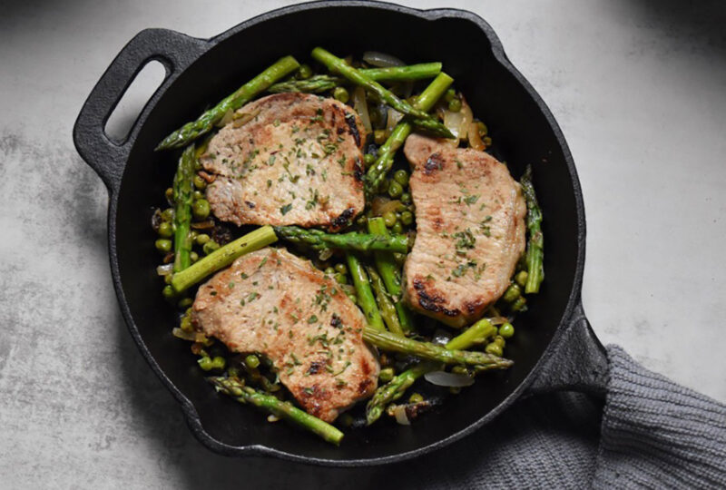 view from above of a skillet with pork chops and vegetables