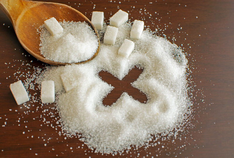 sugar and sugar cubes with spoon and X drawn in them