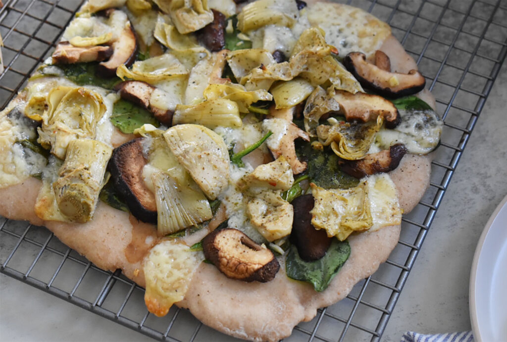 flatbread pizza with veggie toppings on a cooking rack