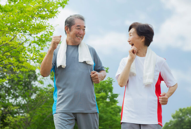 two older adults, man and woman, walking outdoors