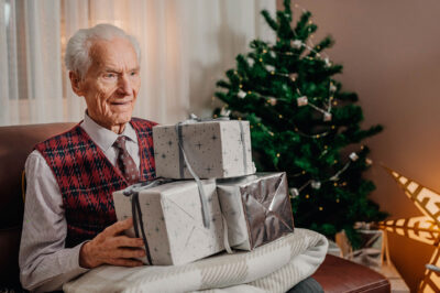Senior Man Holding Christmas Gift in Hands on Christmas