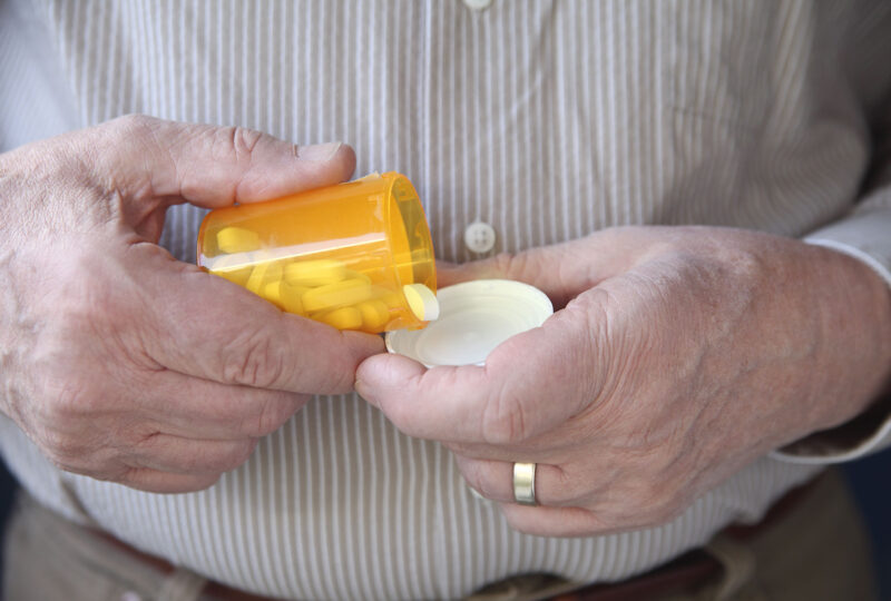 an older man gets ready to take a pill
