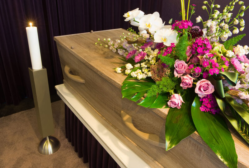 A coffin with flower arrangement in a morgue