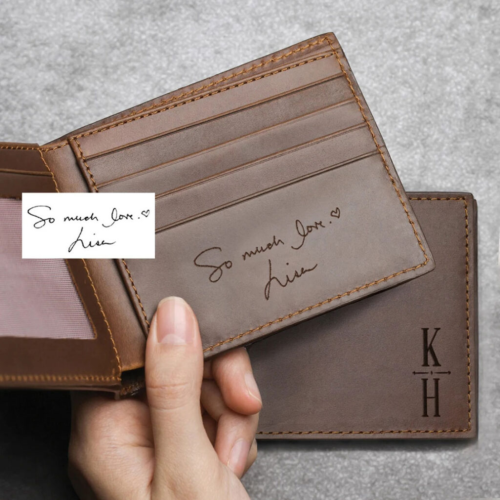 hand holding wallet with engraved writing inside