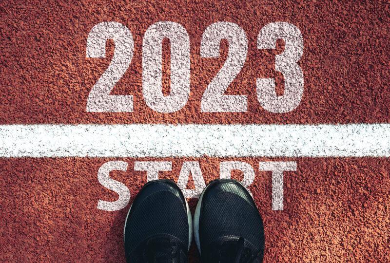 Start 2023 year concept, top view of man shoe on an athletics track engraved with the year 2023. Start of the new year 2023, goals and plans for the next year