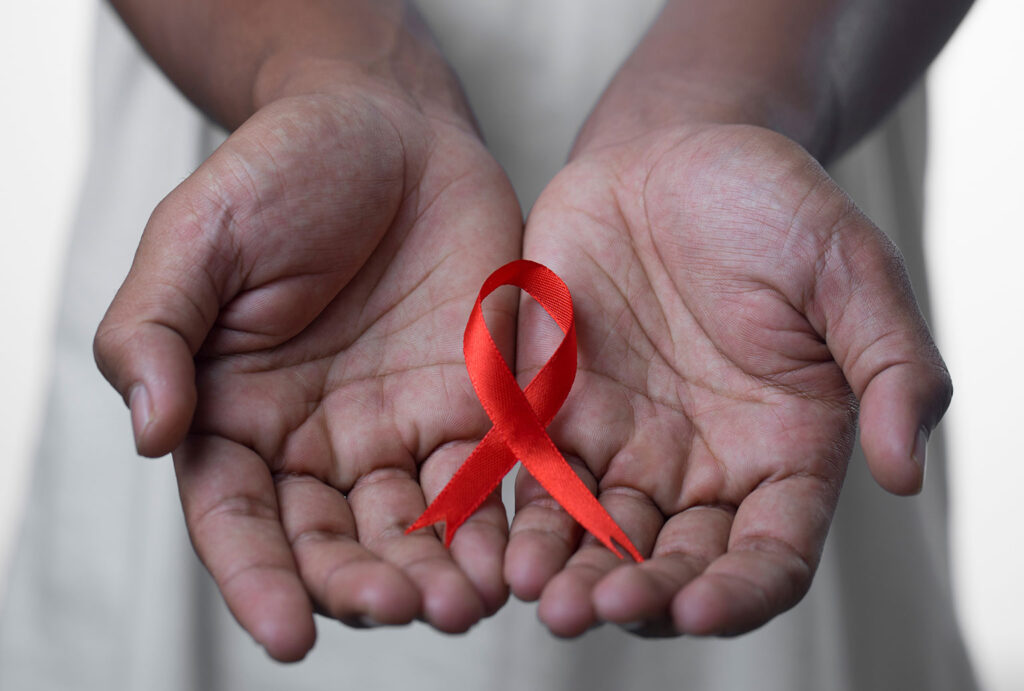 hands holding aids awareness red ribbon