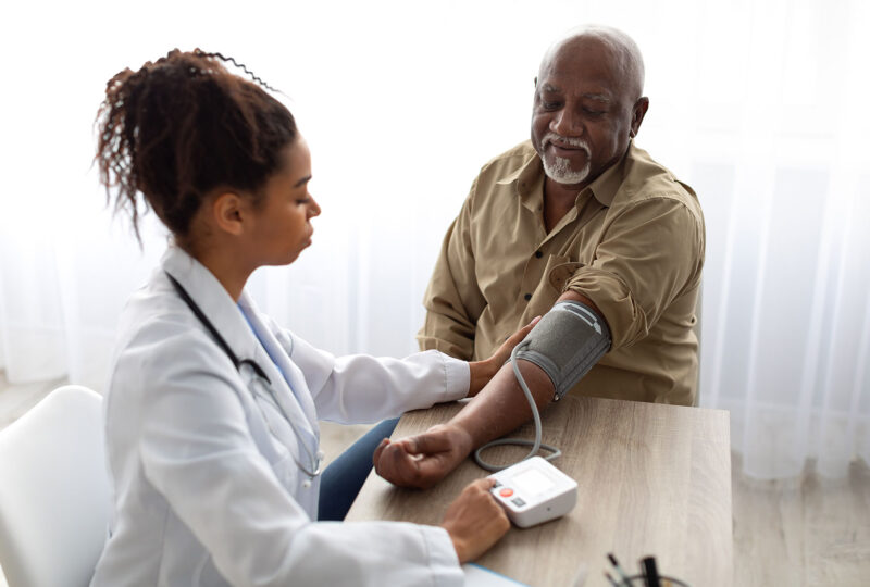 doctor takes older man's blood pressure