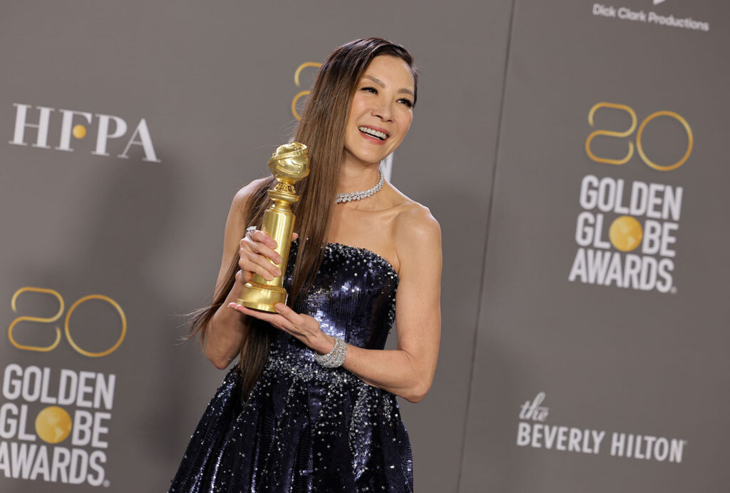 actress michelle yeoh holding golden globe award