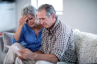 Worried older couple checking the bills at home