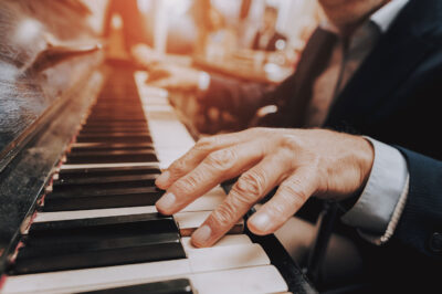 close up of older man's hands playing piano