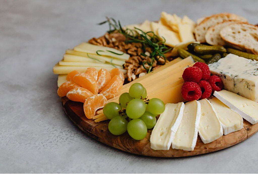 cheese, fruit and nuts on a wooden board