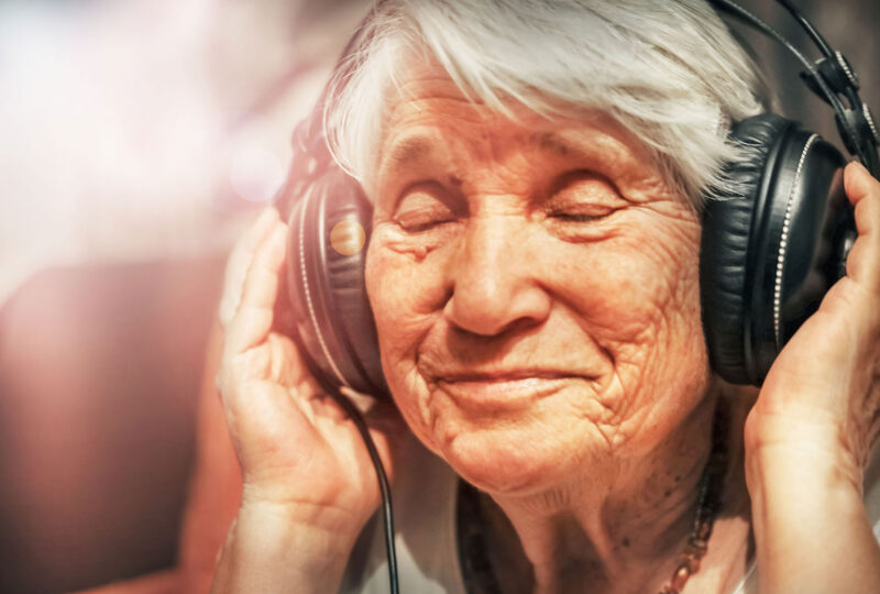 older woman in headphones listening to music