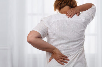 Woman suffering from back and neck pain.