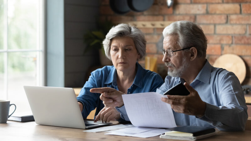 Older couple sitting at a table reviewing documents
