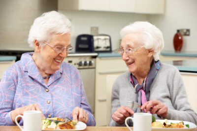 Senior women enjoying a meal together at home
